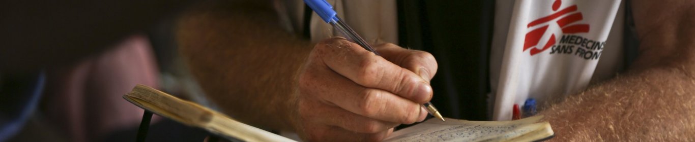 Un membre de MSF prend des notes dans un cahier
