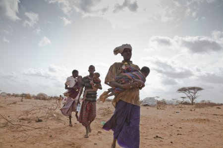 Somali refugees in Dadaab refugee camp carry their sick and malnourished children to a new feeding center