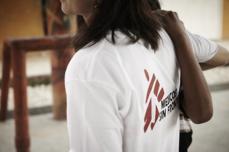 MSF psychologist helps a person to walk