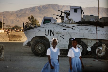 Deux petites filles passent devant un poste de contrôle à Port-au-Prince en Haïti