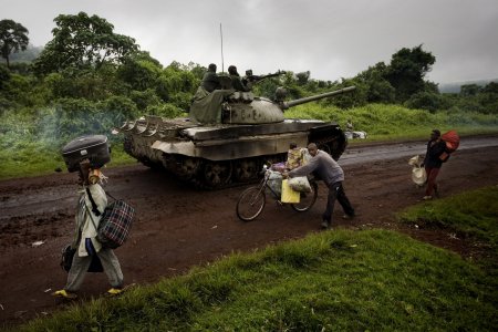 A tank moves towards the frontlines as people are fleeing
