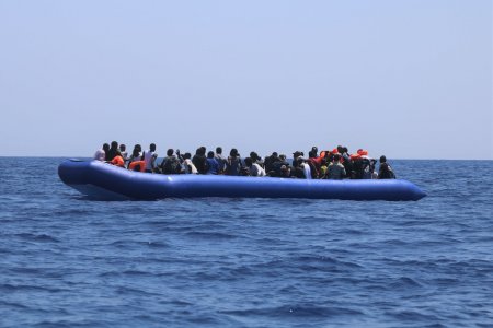 A group of people in distress in a rubber boat before being rescued.